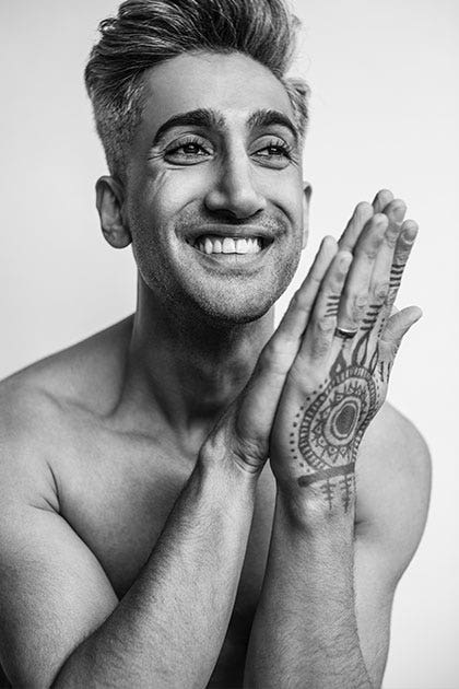 Black and white photo portrait of Tan shirtless, smiling and clasping hands decorated with henna