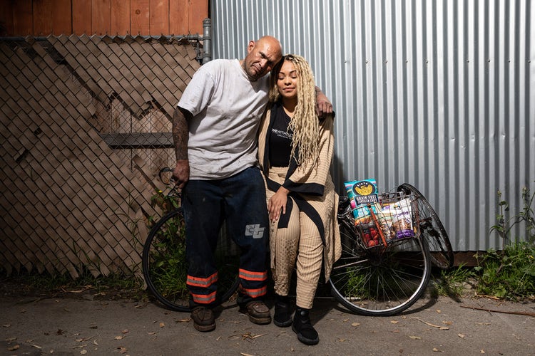 Larayia Gaston poses with a friend in front of a bicycle on a street in Los Angeles